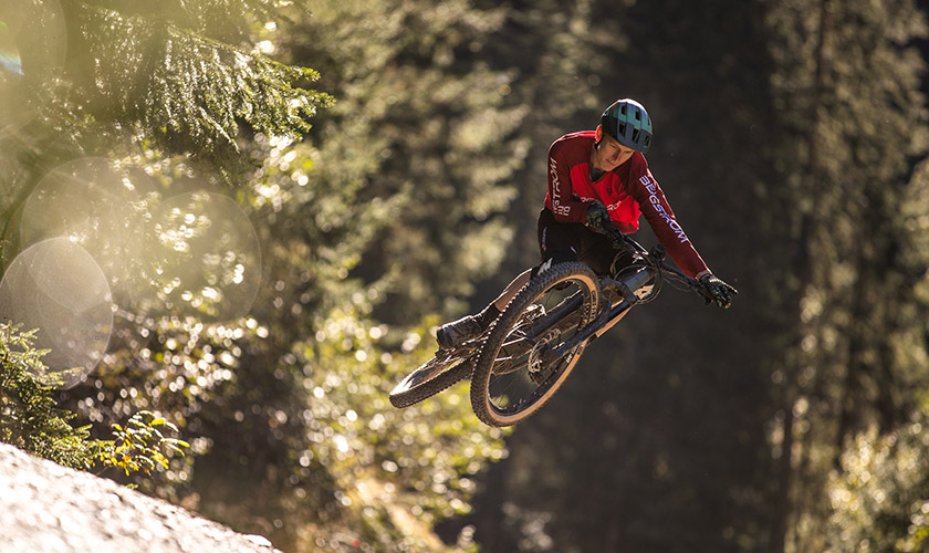 Entdecke die Bergstrom E-Mountainbikes Mann springt mit Bergstrom E-Mountainbike in einem Schweizer Bike-Trail.