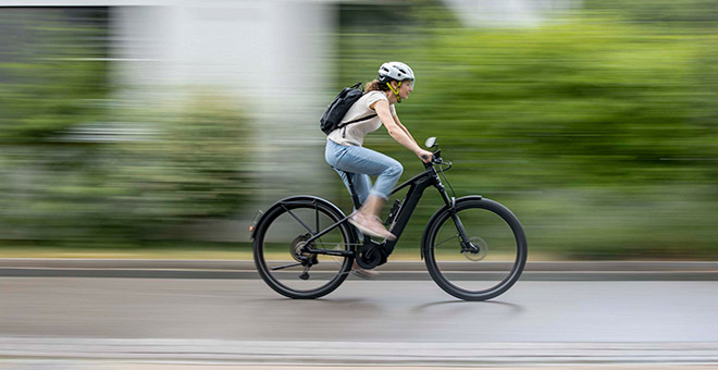 Conduite en ville avec un vélo électrique SUV ATV C de Bergstrom : dynamisme et style réunis Une femme sur un SUV ATV C E-Bike de Bergstrom roule de manière dynamique dans un environnement urbain, en mettant l'accent sur la vitesse et l'agilité.